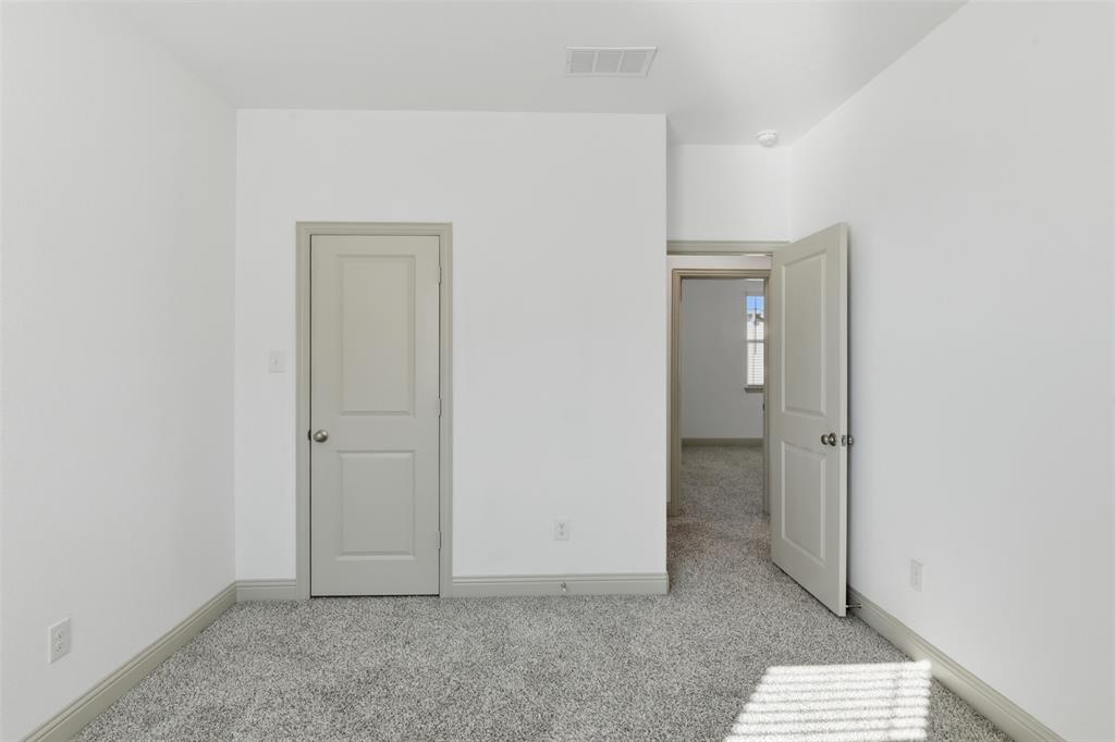 Neutral interior space featuring high-pile wall-to-wall carpeting, two-panel interior doors, and a neutral paint palette