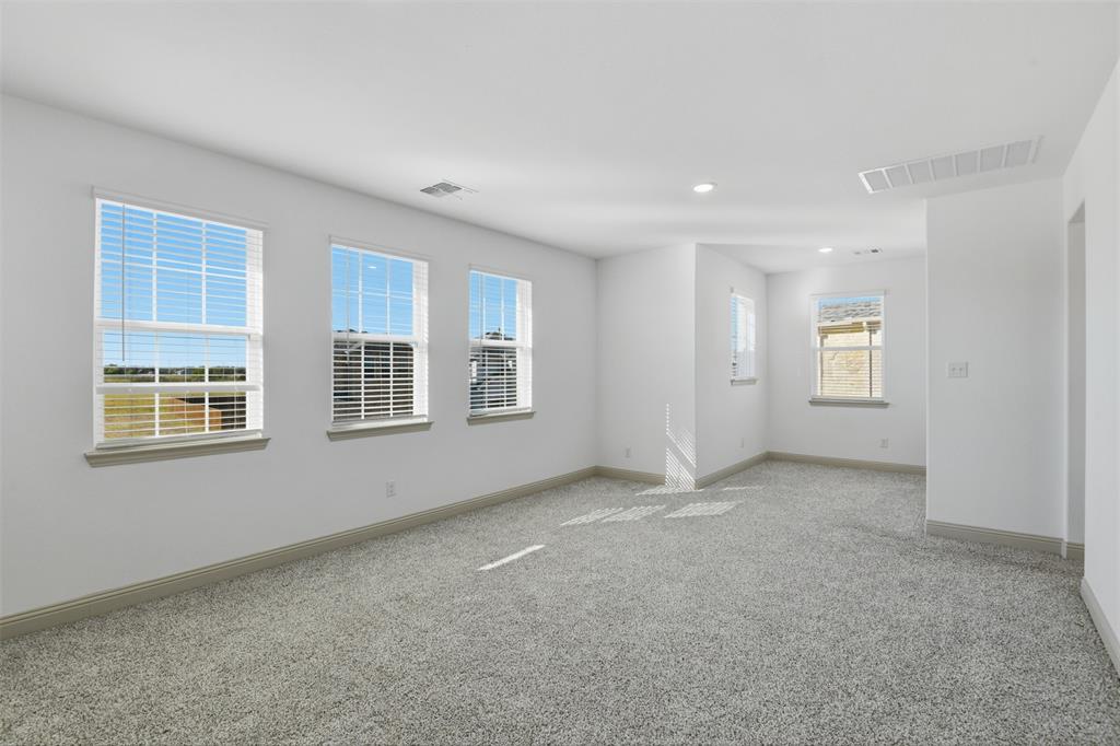 Neutral-toned carpeted flooring, white walls, multiple windows with blinds, and recessed lighting