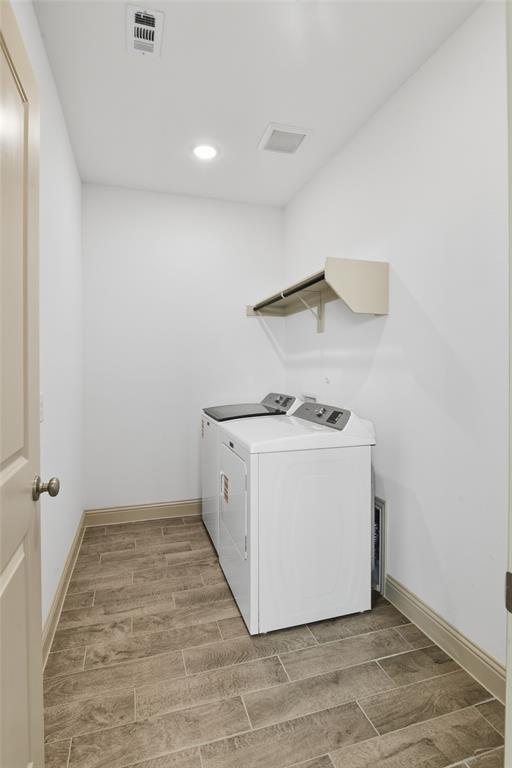 Dedicated laundry area featuring wood-finish tile flooring and built-in shelving