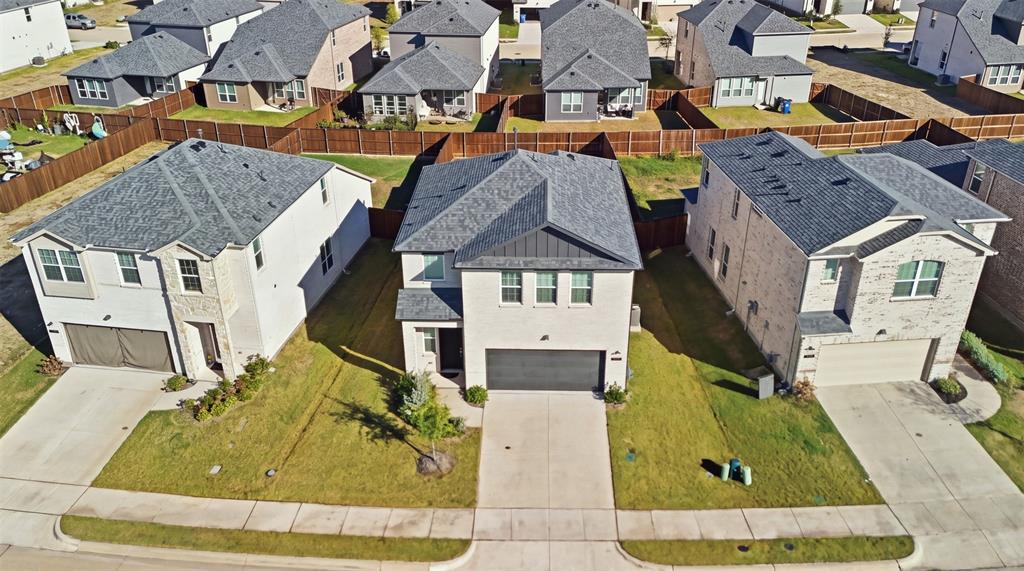 Two-story residence featuring a light brick facade, metal roofing accents, asphalt shingle roofing, and an attached two-car garage