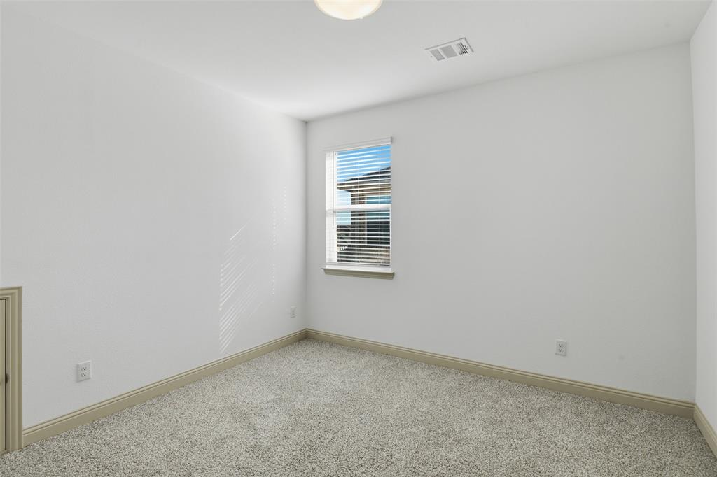 Neutral interior space featuring crisp white walls, neutral-toned wall-to-wall carpeting, and a single-hung window with horizontal blinds