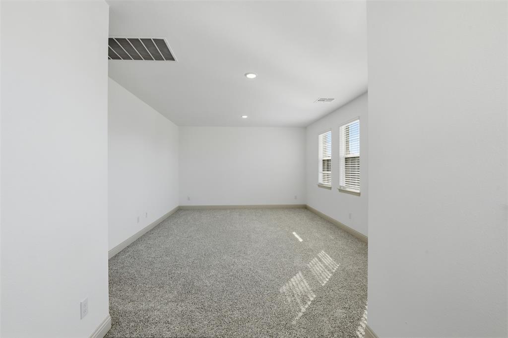 Neutral interior space featuring carpeted flooring, recessed lighting, and dual windows