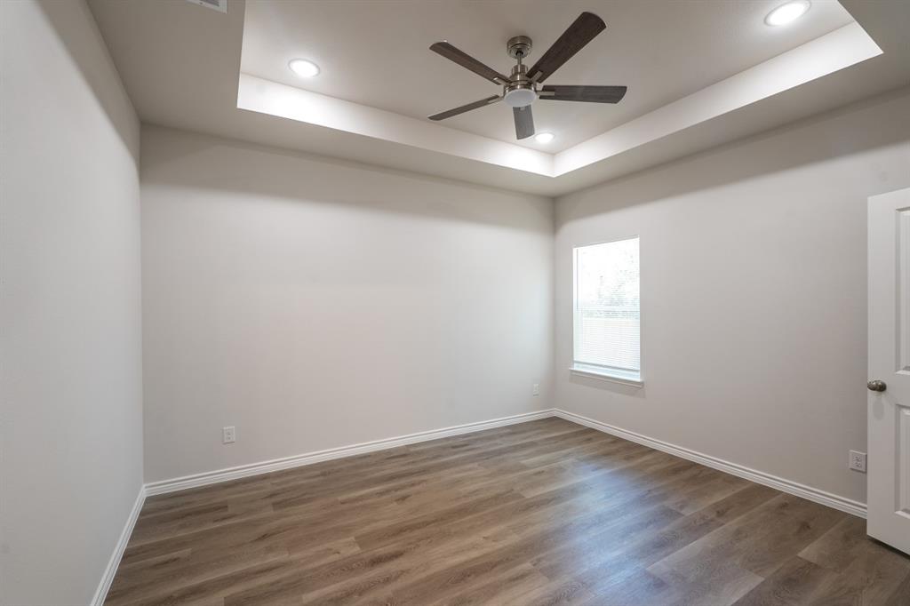 Tray ceiling featuring a brushed nickel ceiling fan, recessed lighting, and wood-finish flooring