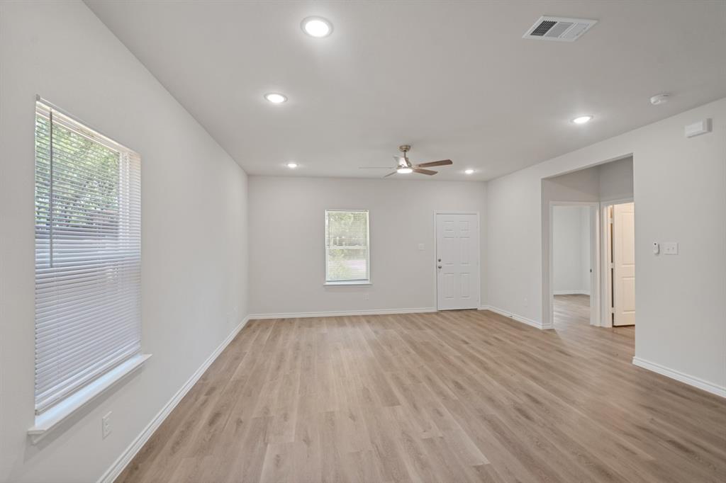 Neutral-toned interior featuring wood-finish flooring, recessed lighting, and a ceiling fan