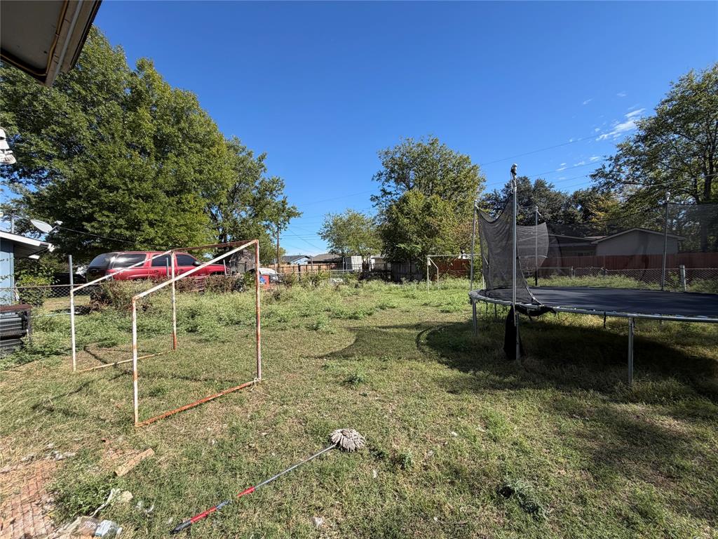 Expansive backyard featuring mature trees and perimeter fencing