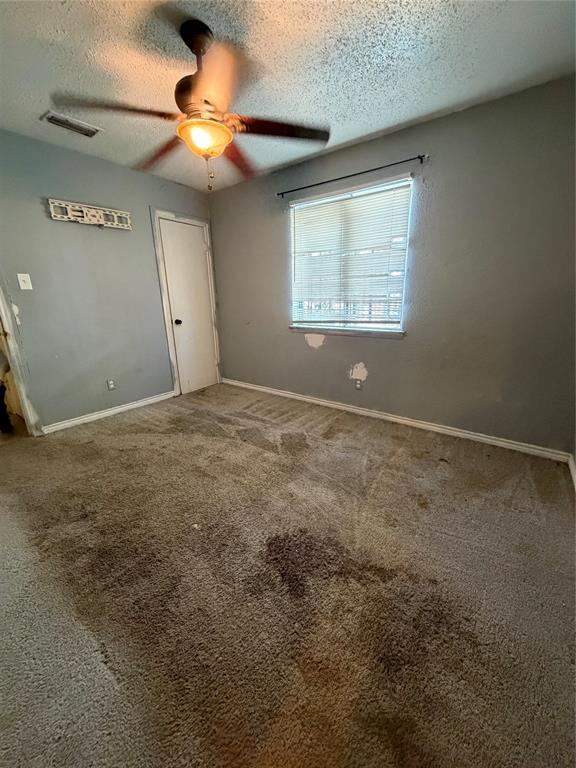 Interior space featuring a ceiling fan with integrated lighting, a single-panel interior door, and a horizontal window with installed blinds