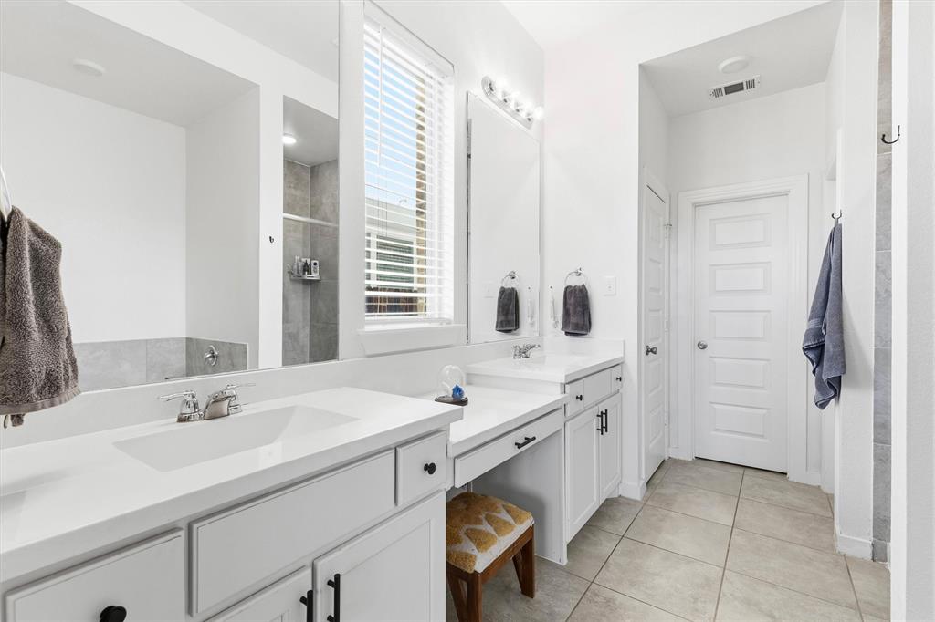 Dual vanity with white cabinetry, rectangular under-mount sinks, light-colored countertops, large wall-mounted mirrors, and ceramic tile flooring