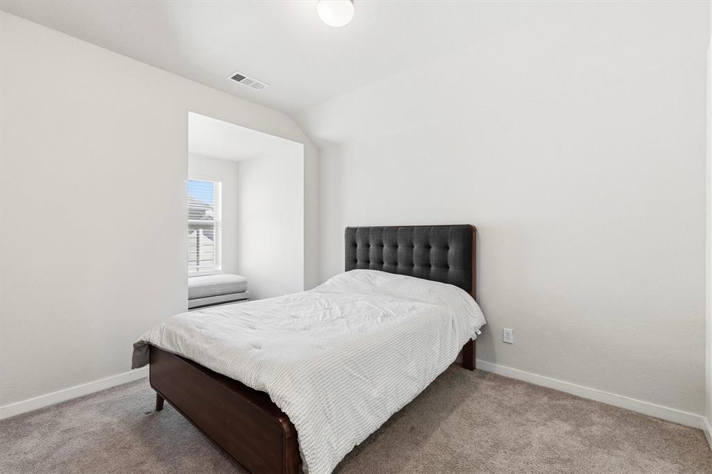Neutral-toned wall finish, recessed alcove with window, and wall-to-wall carpeting