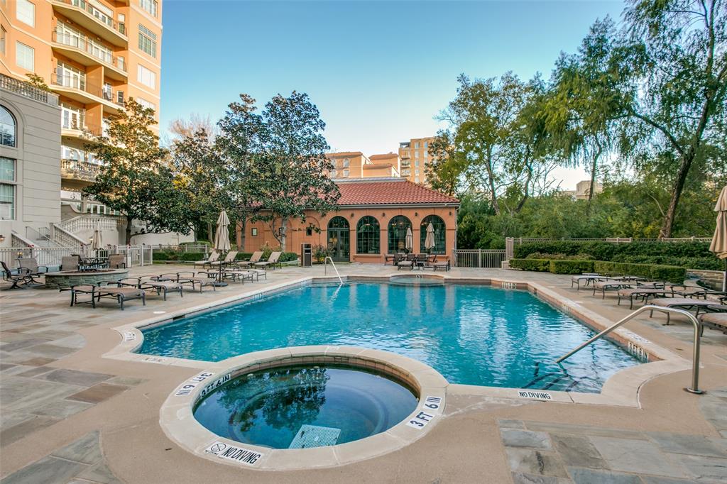 Mediterranean resort style pool and hot tub surrounded by lounge chairs & a cozy fire pit.