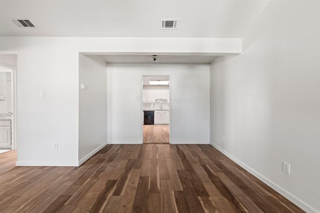 Neutral interior space featuring wood-finish flooring and smooth-finish walls