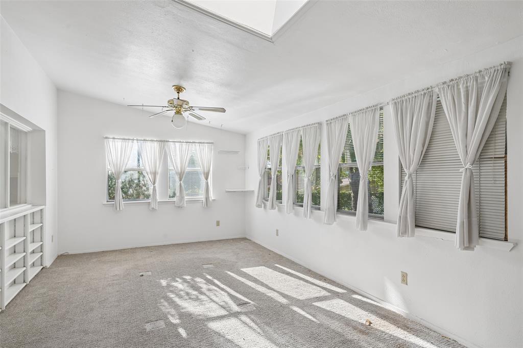 A wall of windows and a skylight fill the game room with light.