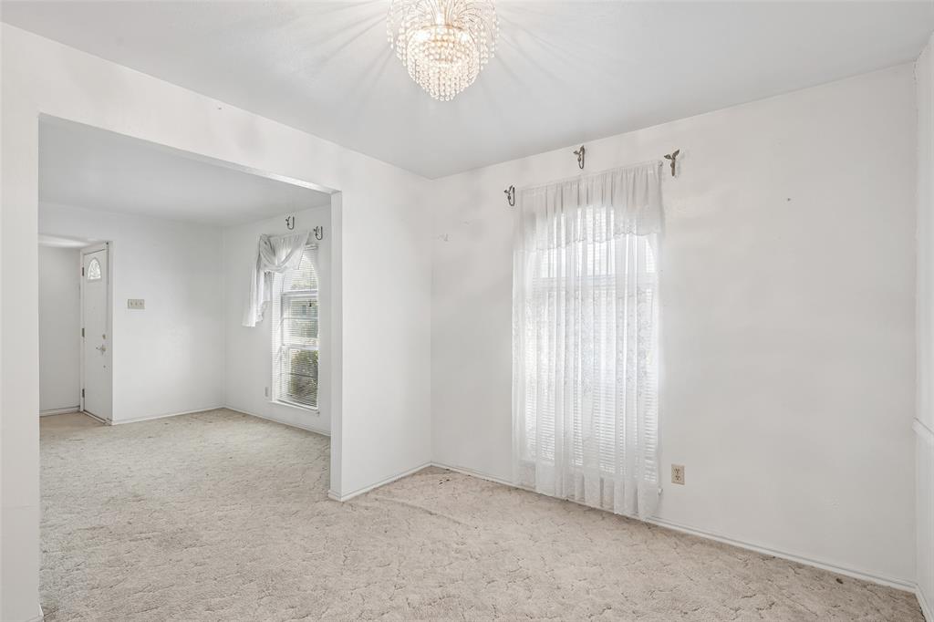 Arched-top window and chandelier light up the dining room.