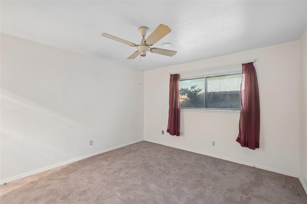 A bright bedroom with a ceiling fan.