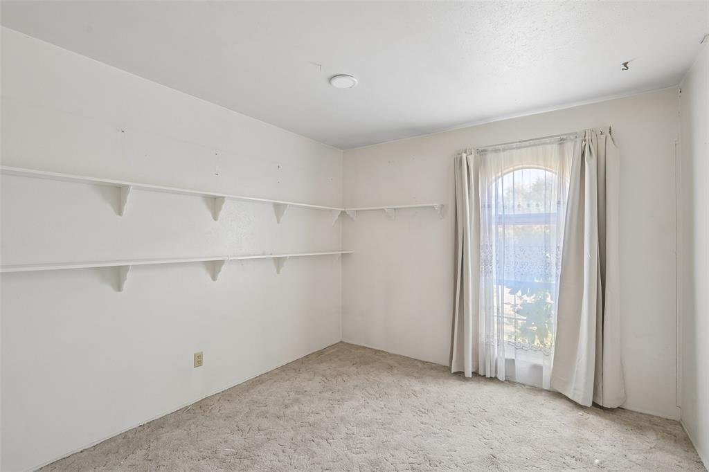 Shelving lines the walls of this bedroom.