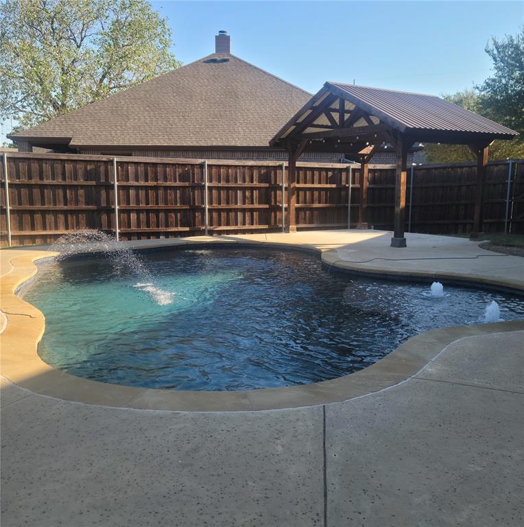 Pool with water features and covered sitting area.