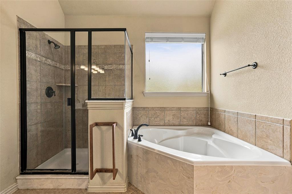 Primary bath has separate tub and shower with privacy window.