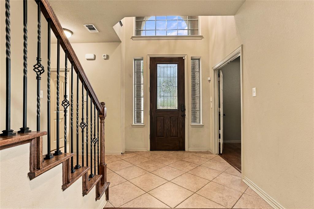 Entry with beautiful stair rail and designer front door.