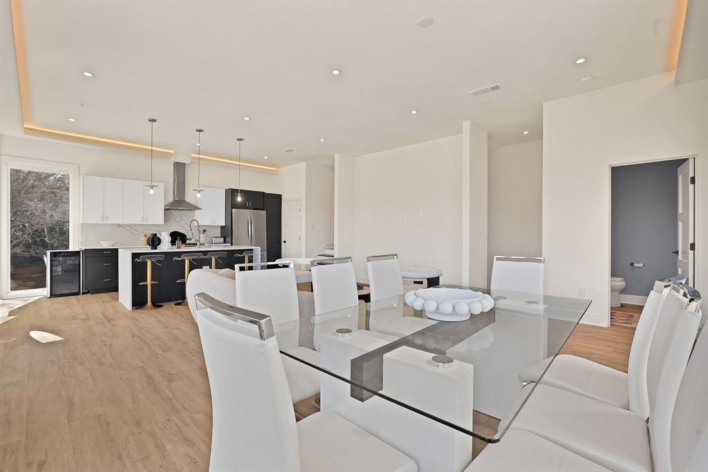 Dining space featuring wine cooler, sink, and light hardwood / wood-style flooring