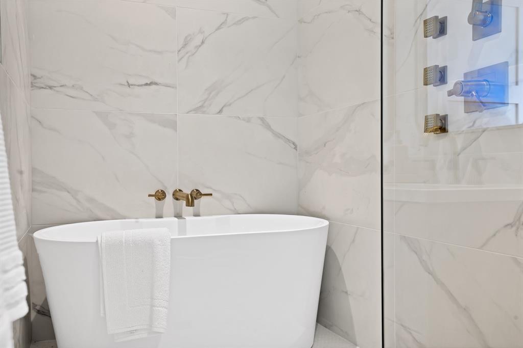Bathroom featuring a tub and tile walls