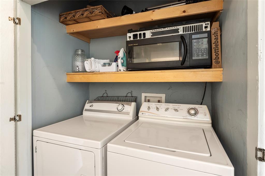 Utility space featuring dual wood shelving and built-in laundry hookups