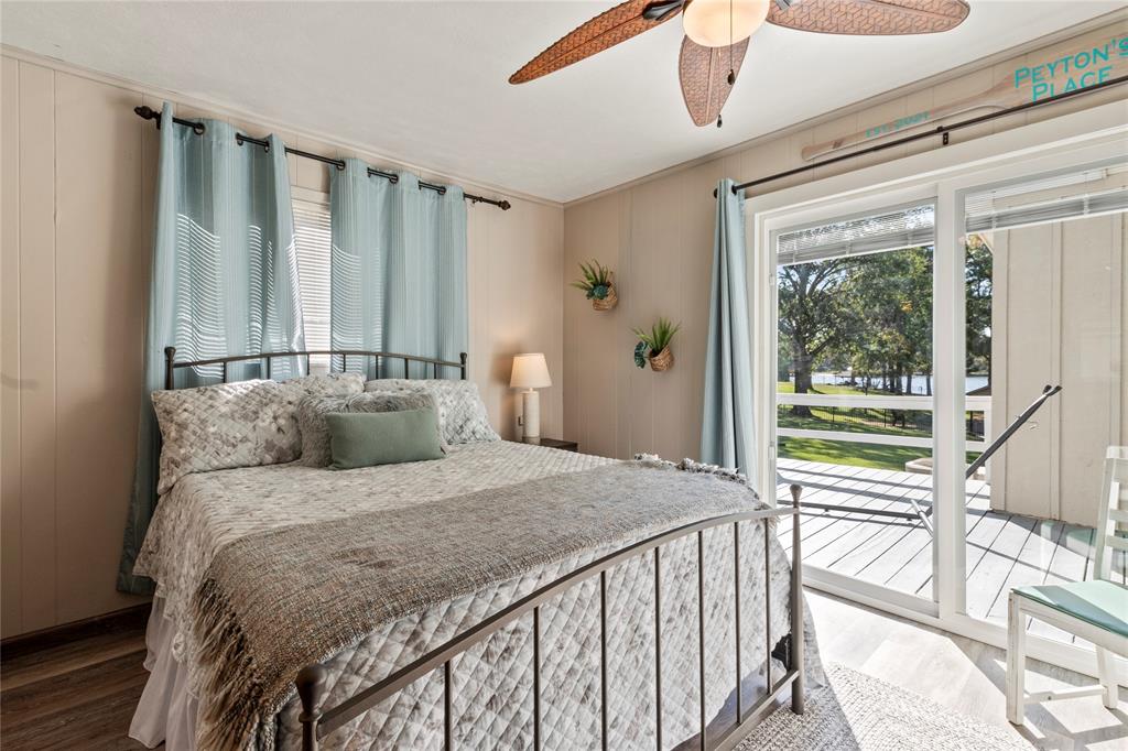 Sliding glass doors providing exterior access, wood-finish flooring, and a ceiling fan with integrated lighting