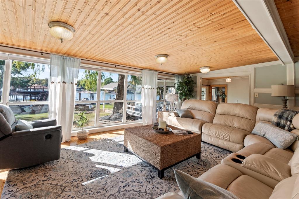 Wood-plank ceiling, wall-to-wall windows, and flush-mount lighting fixtures