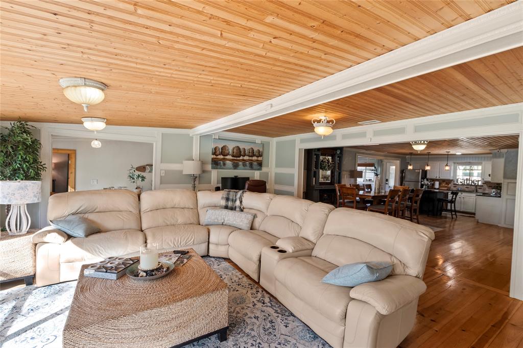 Natural wood-plank ceiling, wide-plank wood flooring, and wainscot wall paneling