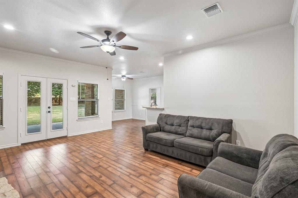 Wood-finish flooring, recessed lighting, ceiling fans, and white trim