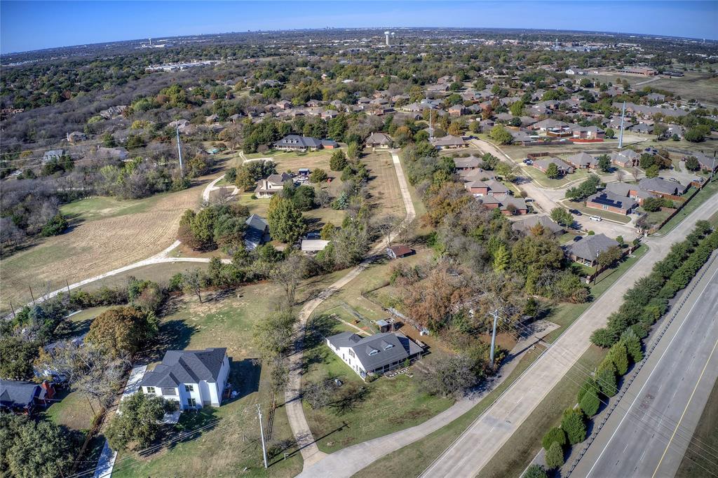 Aerial view of property and surrounding area featuring nearby suburban area
