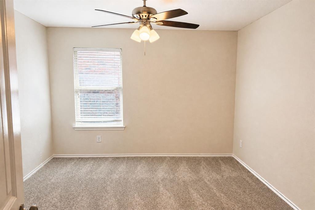 Neutral-toned interior space featuring neutral wall-to-wall carpeting, a single window with horizontal blinds, and a ceiling fan with integrated multi-bulb lighting