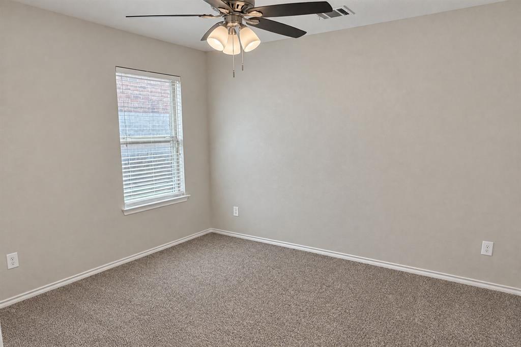 Neutral-toned interior space featuring wall-to-wall carpeting, a multi-blade ceiling fan with integrated tri-light fixture, and a single-pane window with horizontal blinds Neutral-toned interior space featuring wall-to-wall carpeting, a multi-blade ceiling fan with integrated tri-light fixture, and a single-pane window with horizontal blinds