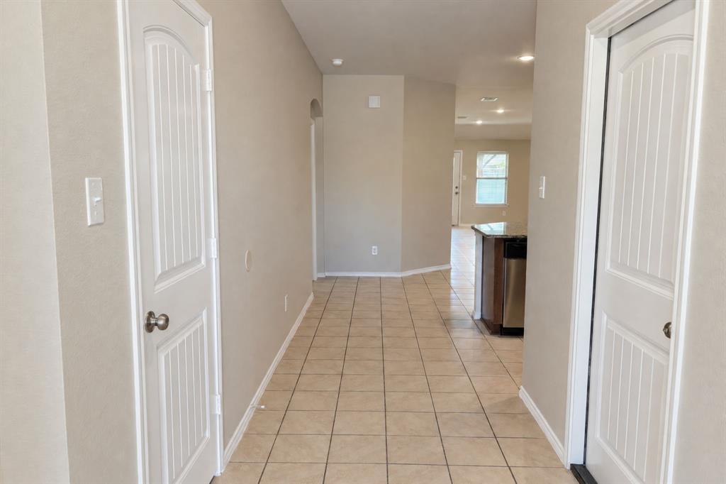 Neutral-toned interior hall featuring tile flooring and two-panel arched interior doors Neutral-toned interior hall featuring tile flooring and two-panel arched interior doors