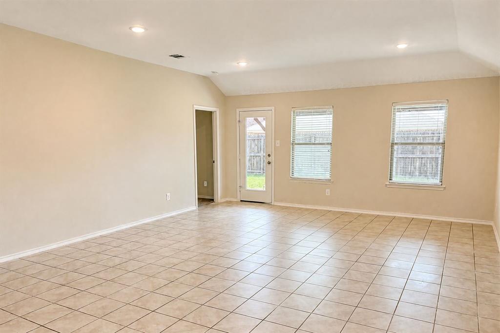 Open-concept space featuring vaulted ceilings, recessed lighting, tile flooring, and multiple windows providing natural light