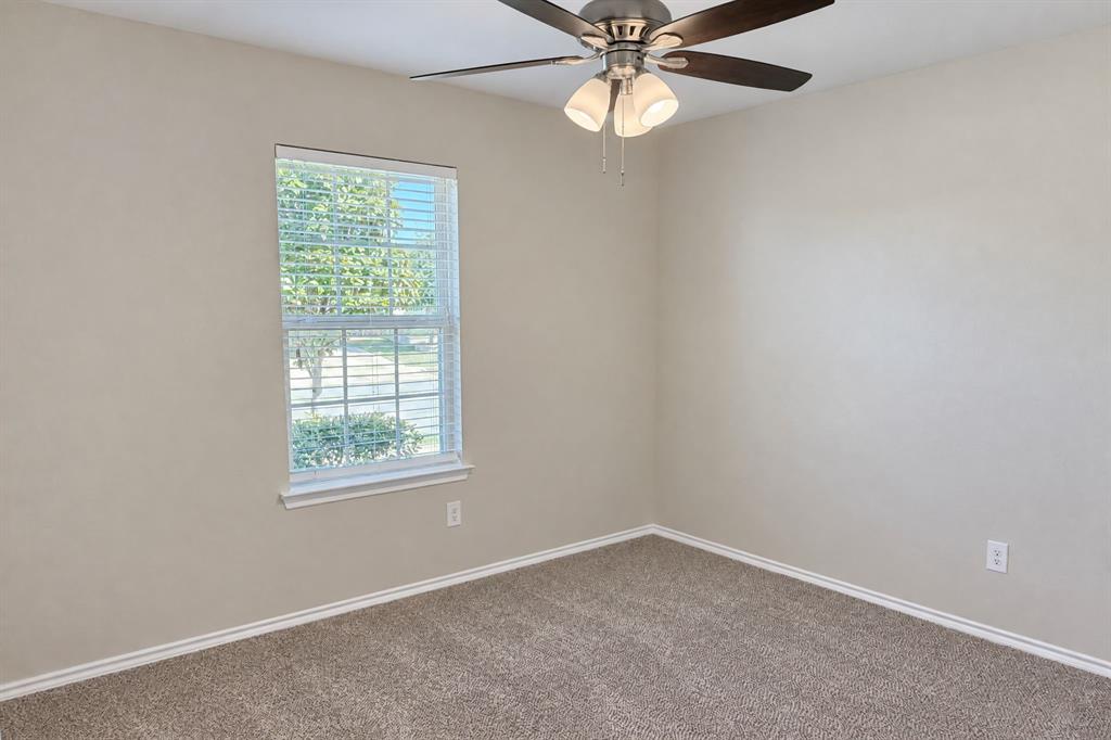 Neutral-toned interior featuring wall-to-wall carpeting, a multi-pane window with blinds, and a ceiling fan with integrated light fixture Neutral-toned interior featuring wall-to-wall carpeting, a multi-pane window with blinds, and a ceiling fan with integrated light fixture