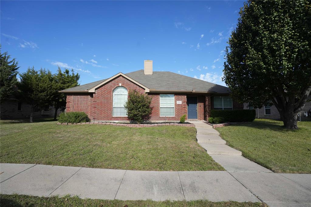 Single-story brick exterior featuring an arched window, a central chimney, and a concrete walkway