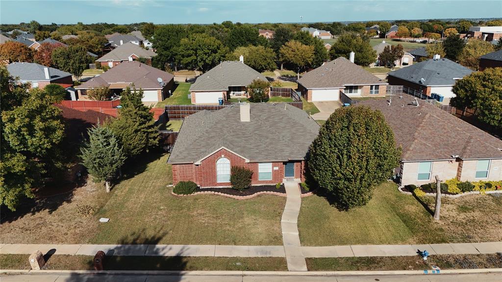 Single-story brick exterior residence featuring a composition shingle roof, arched window detail, and a concrete walkway