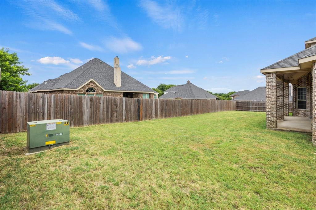 Backyard featuring a lawn, privacy wood fencing, and a concrete patio