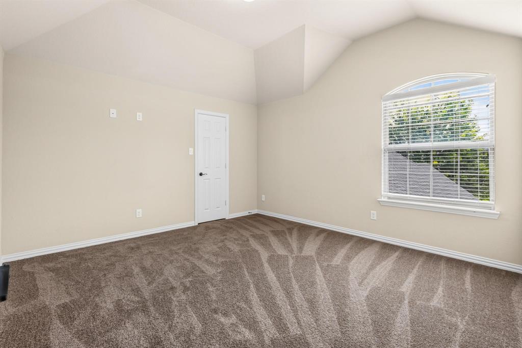 Vaulted ceilings, neutral wall tones, arched window with horizontal blinds, and wall-to-wall carpeting