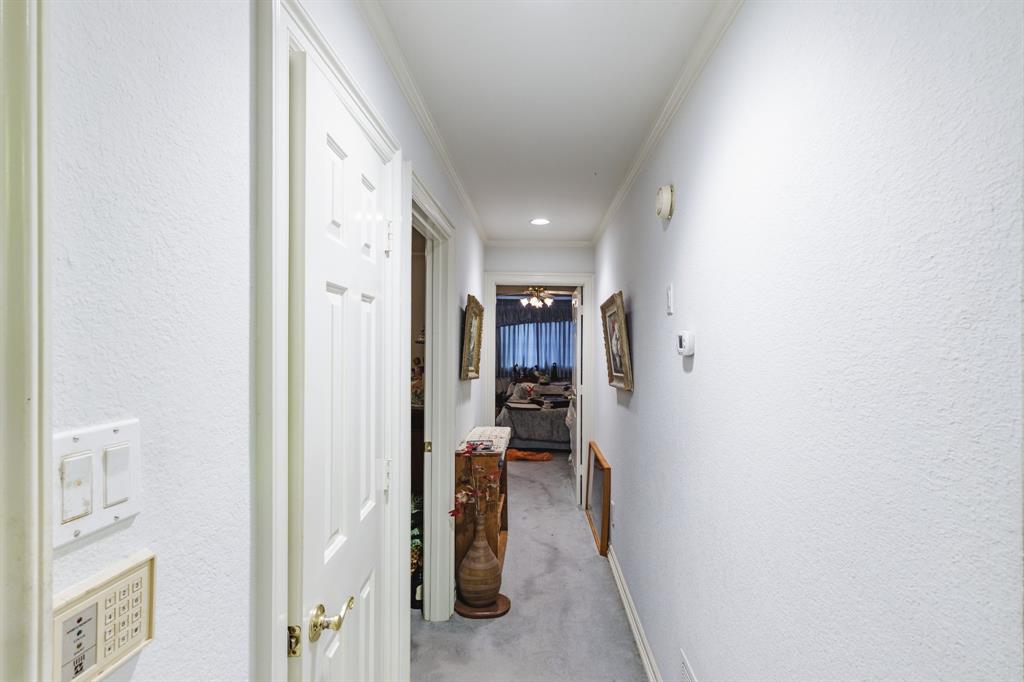 Hallway featuring crown molding, recessed lighting, and solid-core six-panel interior doors with brass-finish hardware