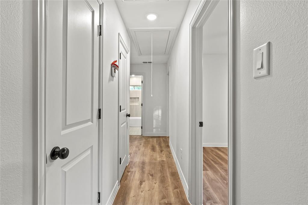 Hall featuring attic access and light wood-style flooring