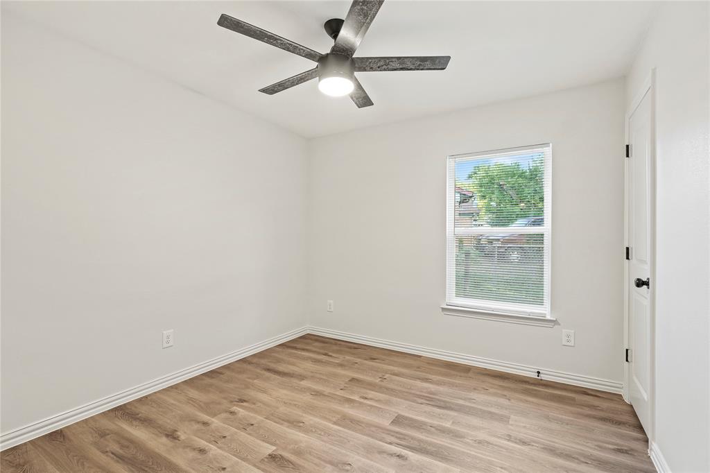 Unfurnished room with light wood finished floors, a ceiling fan, and baseboards