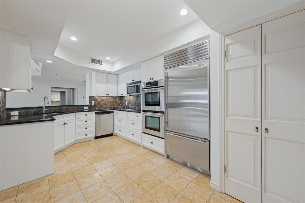 Kitchen featuring white cabinetry, granite countertops  , tile backsplash, SS appliances