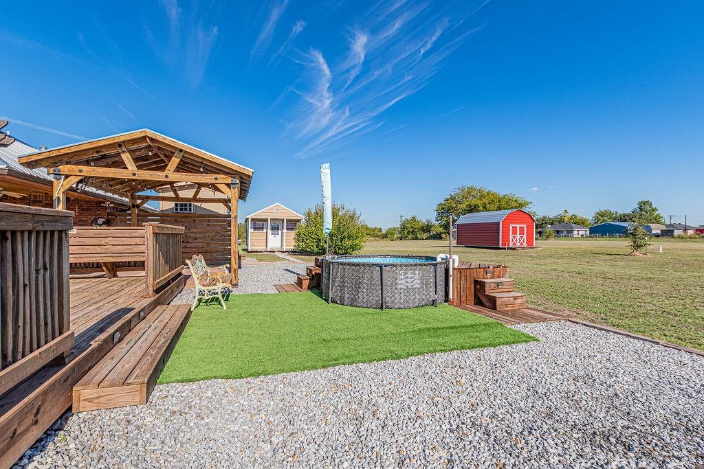 Outdoor space featuring 2 out buildings and gravel hardscaping