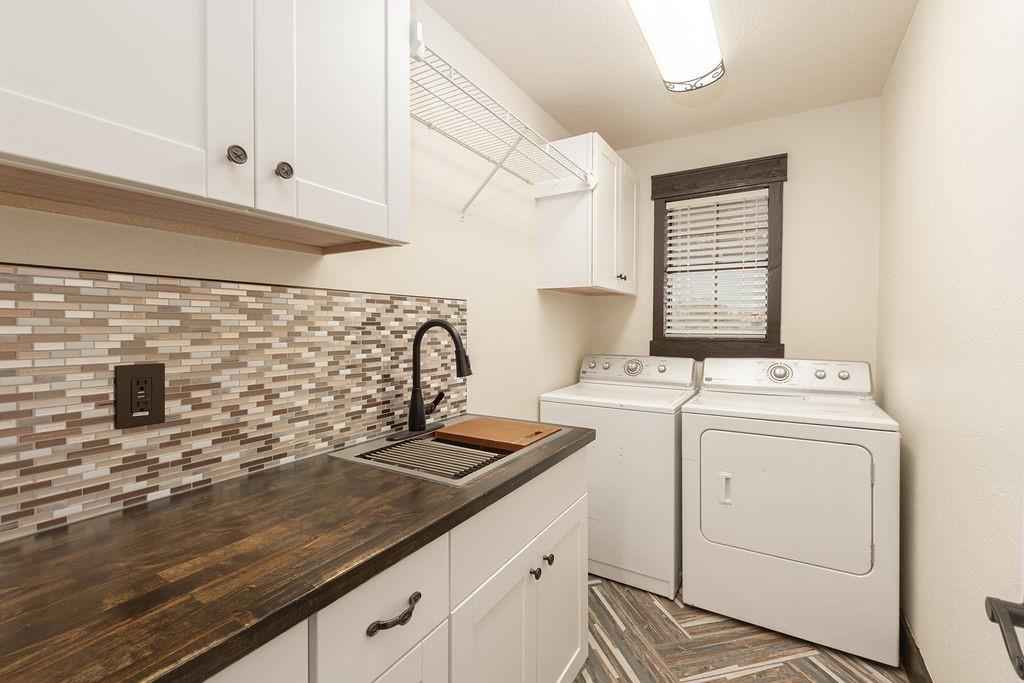 Laundry room with cabinets, a sink and a hanging area.