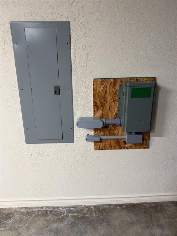 Electrical panel featuring a flush-mount enclosure and an externally mounted secondary disconnect box on an oriented strand board backing