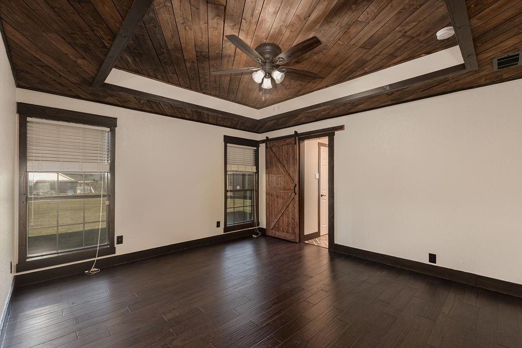 The primary bedroom features a wooden tray ceiling