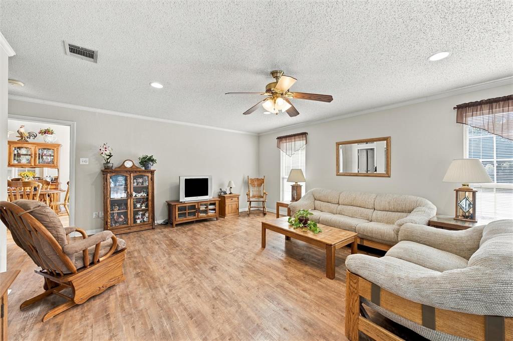 Living area featuring wood-finish flooring, recessed lighting, and a central ceiling fan with integrated light fixture