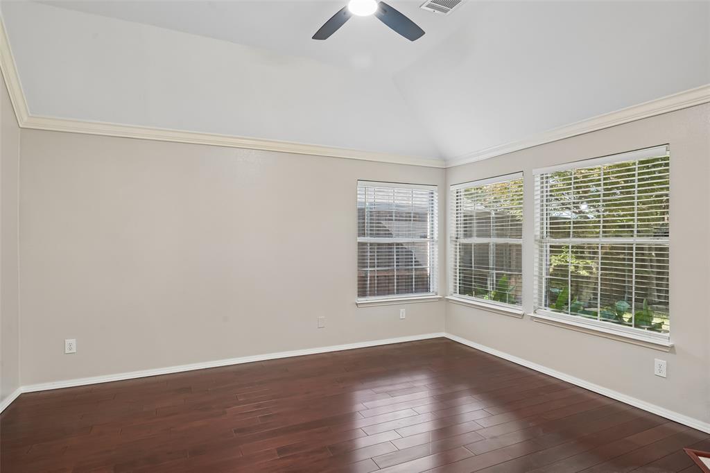 Vaulted ceilings with crown molding, wood-finish flooring, and multiple windows with horizontal blinds