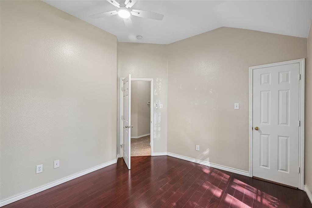 Vaulted ceilings, wood-finish flooring, and a central ceiling fan with integrated lighting