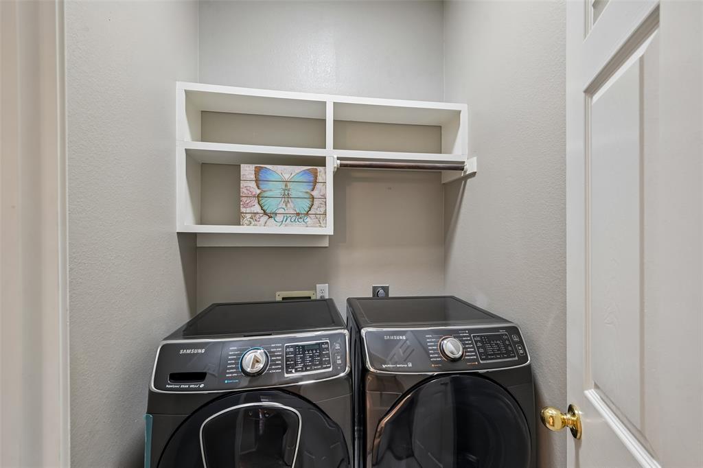 Laundry area featuring white built-in shelving and a horizontal hanging rod